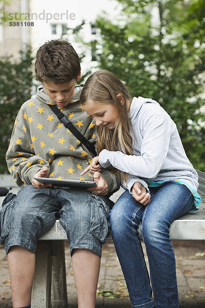 Junge und Mädchen mit digitalem Tablett