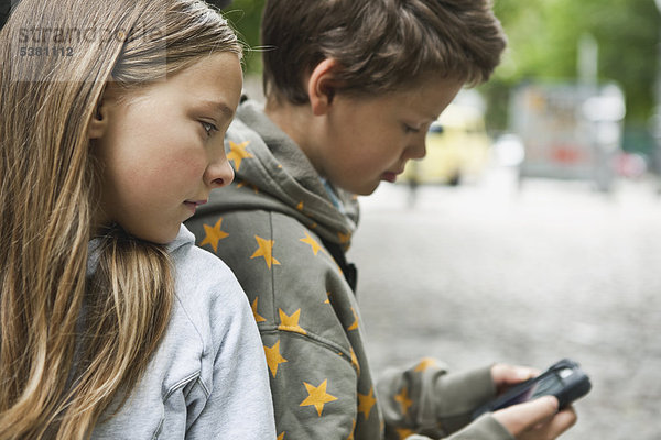 Junge und Mädchen mit Handy