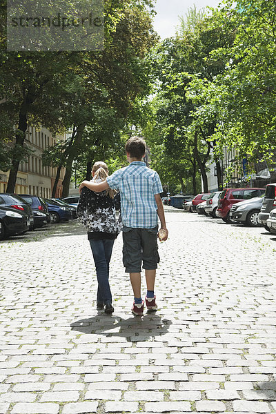 Junge und Mädchen gehen als Paar auf der Straße spazieren.