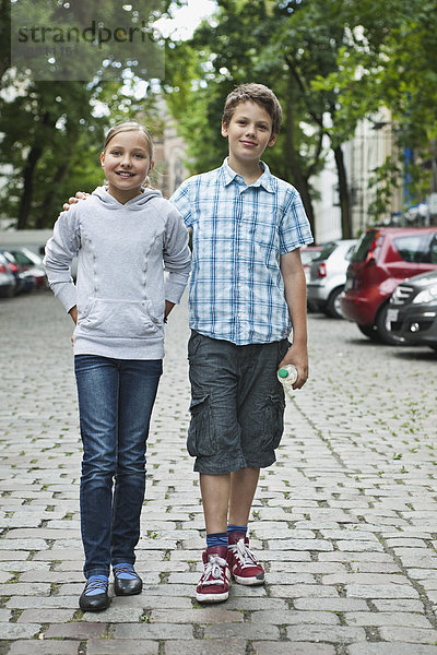 Junge und Mädchen gehen als Paar auf der Straße spazieren.