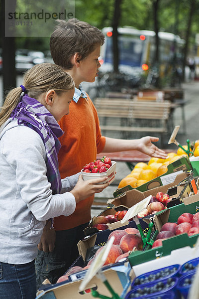 Junge und Mädchen auf dem Gemüsemarkt