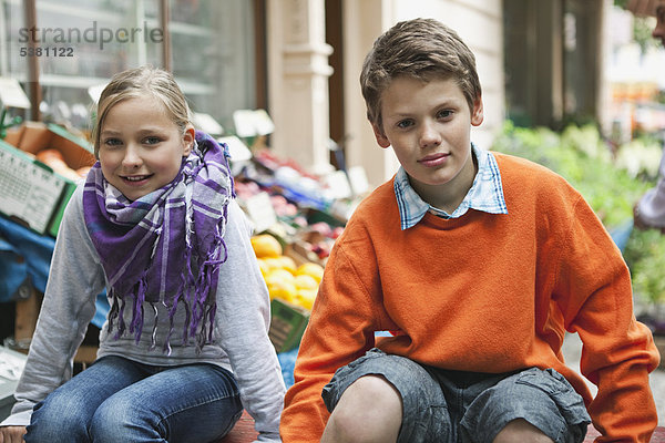 Junge und Mädchen auf dem Gemüsemarkt