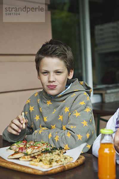 Junge und Mädchen essen Pizza im Cafe