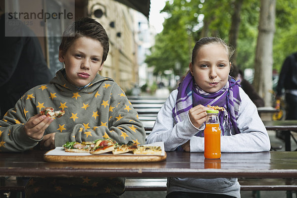 Junge und Mädchen essen Pizza im Cafe