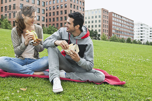 Deutschland  Berlin  Paar beim Essen im Park