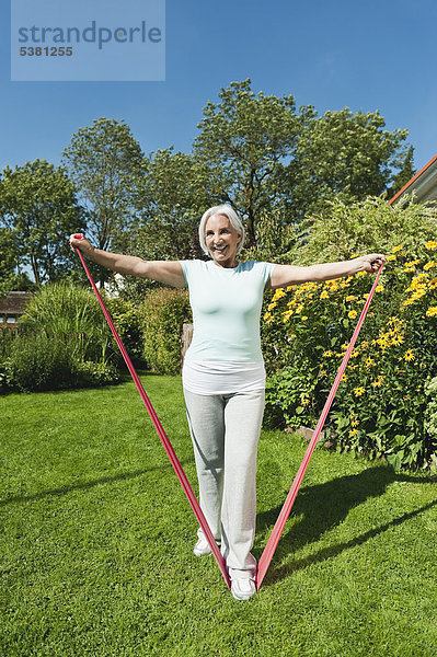 Seniorin beim Sport mit Gummiseil