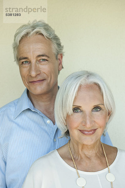 Reifer Mann und ältere Frau vor weißem Hintergrund  Nahaufnahme  lächelnd  Porträt