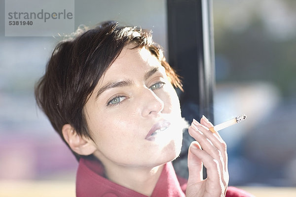 Frau raucht Zigarette im Freien