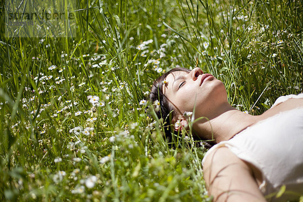 Frau schläft im hohen Gras