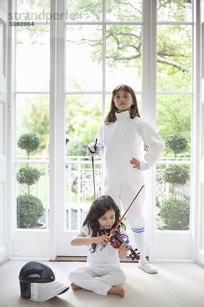 Mädchen mit Geige und Fechtkleidung