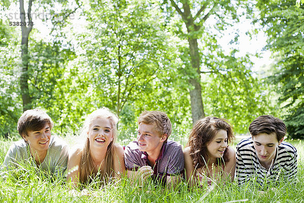 Teenager liegen im Gras im Park