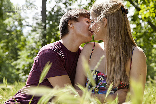 Teenager-Pärchen beim Küssen im hohen Gras