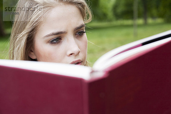 Teenager-Mädchen beim Lesen im Park