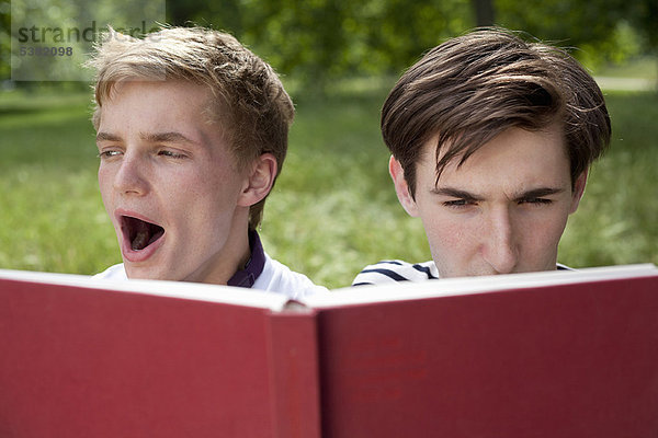 Teenager Jungen beim Lesen im Park