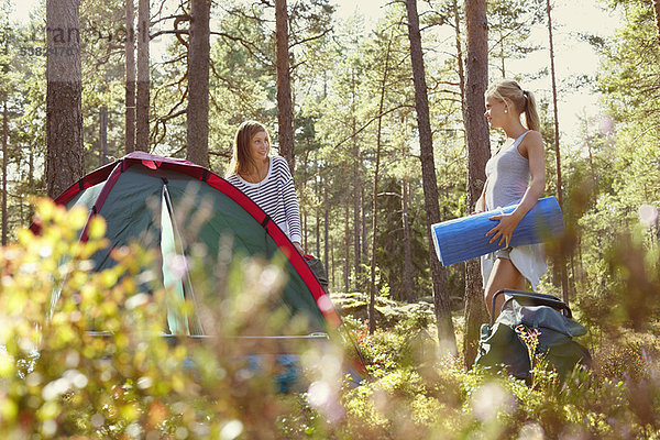 Frauen beim Aufbau eines Campingplatzes im Wald