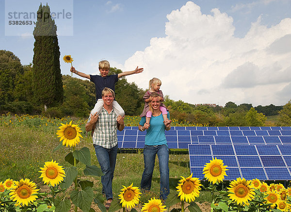 Familie im Feld durch Sonnenkollektoren