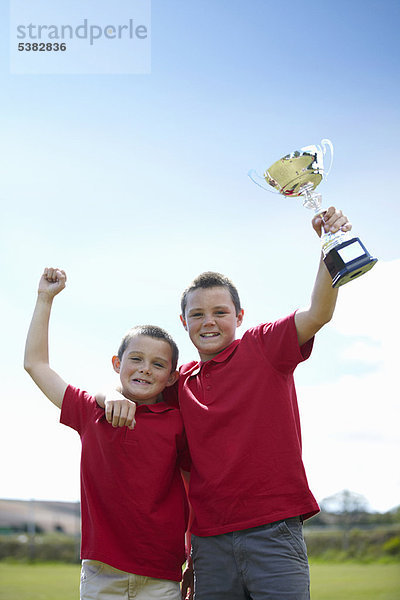 Außenaufnahme  Junge - Person  jubeln  freie Natur  Pokal