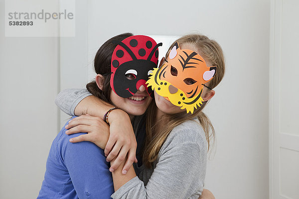 Lächelnde Mädchen mit bunten Masken