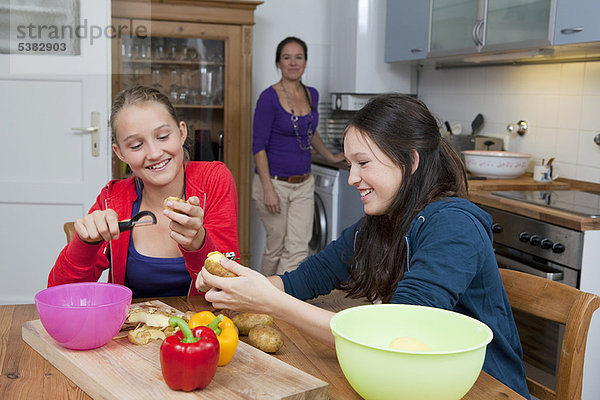 Mädchen schälen Gemüse in der Küche