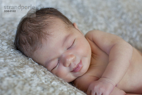 Neugeborenes Baby  5 Tage  lächelt im Schlaf