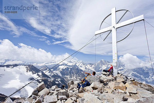 Bergsteiger am Gipfelkreuz  Vertainspitze  Ortlergebiet  hinten der König  Südtirol  Italien  Europa