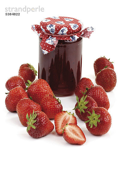 Ein Glas Erdbeermarmelade und frische Erdbeeren