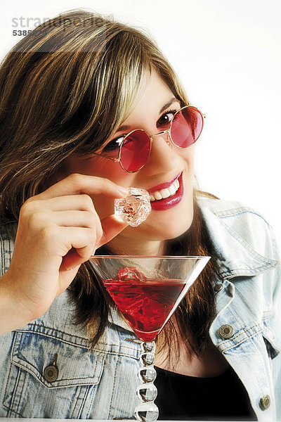 Junge Frau mit rosaroter Sonnenbrille und Cocktail