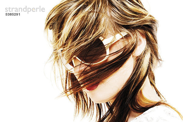 Junge Frau mit Sonnenbrille im Wind