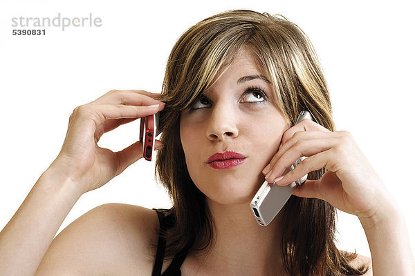 Junge Frau telefoniert mit zwei Handys
