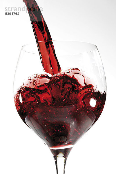 Rotwein in ein Glas schütten