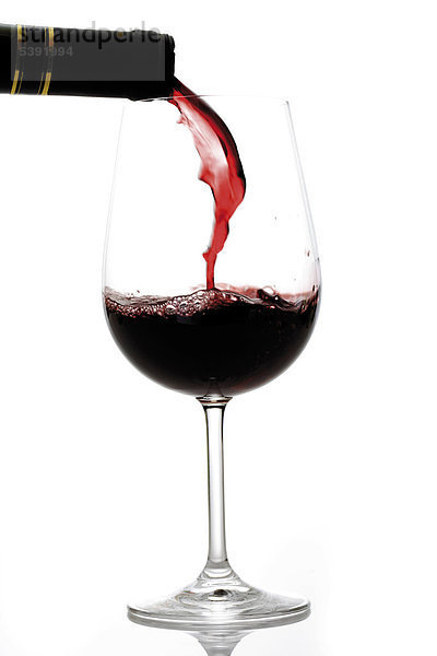 Rotwein in ein Glas schütten