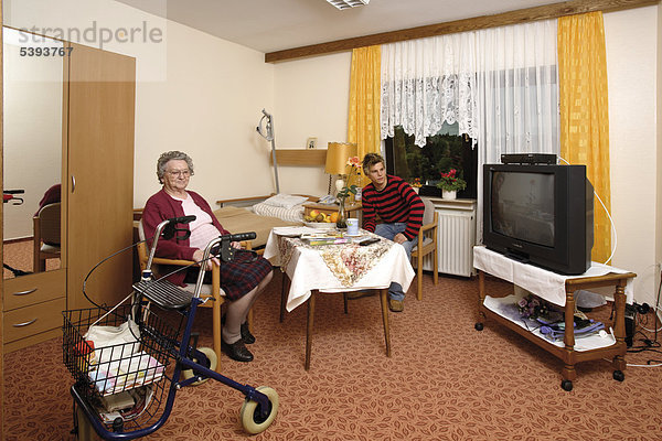 Zimmer im Altenheim  Pflegeheim  Seniorin hat Besuch vom Enkel