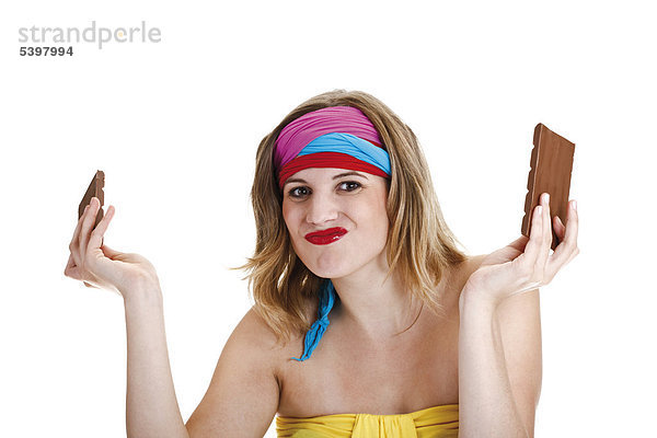 Junge Frau mit bunten Haarbändern und zerbrochener Schokoladentafel