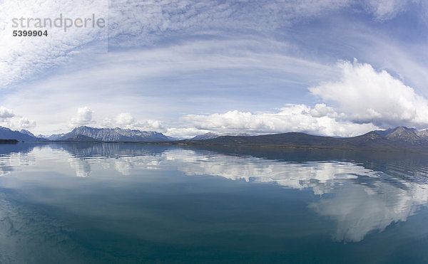 Wolken spiegeln sich im ruhigen Atlin Lake See  hinten Berge  Tagish Highland  British Columbia  Kanada  Amerika