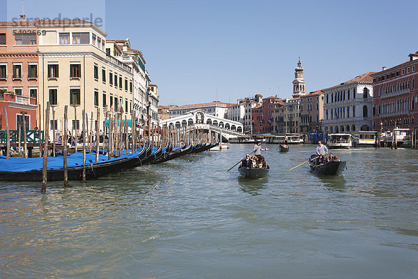 Der Canal Grande mit der Rialtobrücke  Gondoliere in venezianischen Gondola  daneben parkende Gondeln  Venedig  Italien  Europa