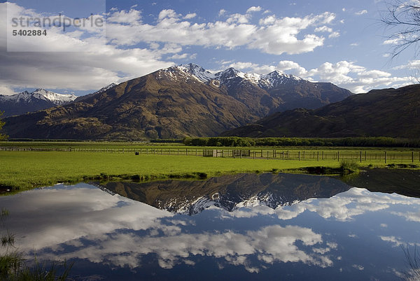 Berge der Neuseeländischen Alpen spiegeln sich in einem ruhigen Teich in der Nähe vom See Lake Wanaka  Südinsel  Neuseeland