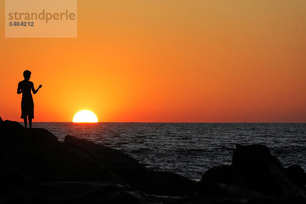 Silhouette einer Person bei Sonnenuntergang  Strand Las Penitas bei Poneloya  Leon  Pazifik  Nicaragua  Zentralamerika