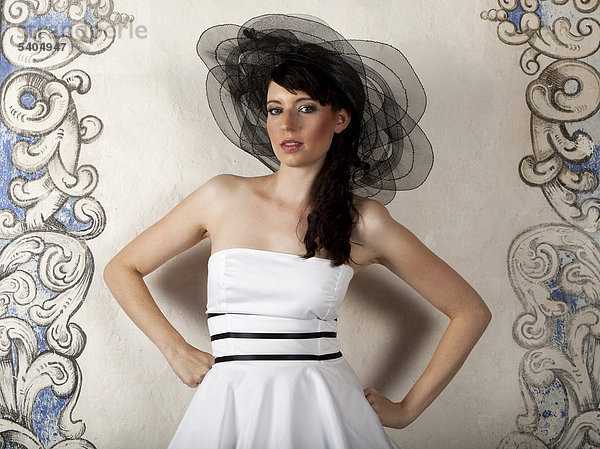 Junge Frau mit Hut und weißem Kleid