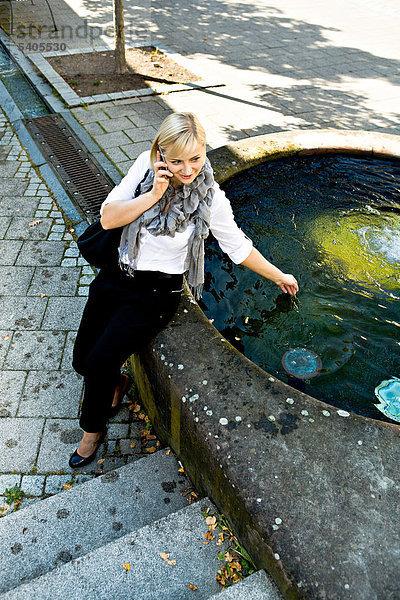 Junge Frau mit Handy  urbane Umgebung