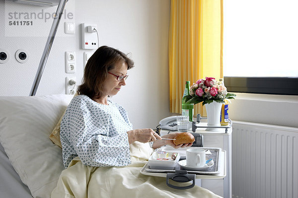Patientin im Krankenbett nimmt eine Mahlzeit zu sich  Krankenhaus