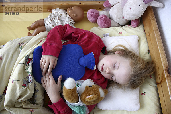 Mädchen  10 Jahre  liegt krank mit einer Wärmflasche im Bett  hat Grippe  Erkältung  Schnupfen  Fieber