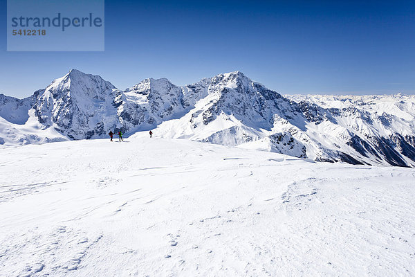 Skitourengeher beim Abstieg von der hinteren Schöntaufspitze  Sulden im Winter  hinten Königsspitze  Zebru und Ortler  Südtirol  Italien  Europa