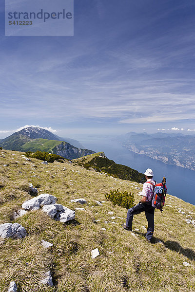 Bergsteiger auf dem Monte Altissimo oberhalb von Nago-Torbole  unten der Gardasee  hinten der Monte Baldo  Trentino  Italien  Europa