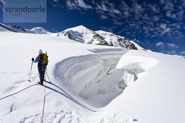 Bergsteiger beim Aufstieg zum Piz Palü durch die Gletscherlandschaft  hinten der Gipfel des Piz Palü  Graubünden  Schweiz  Europa