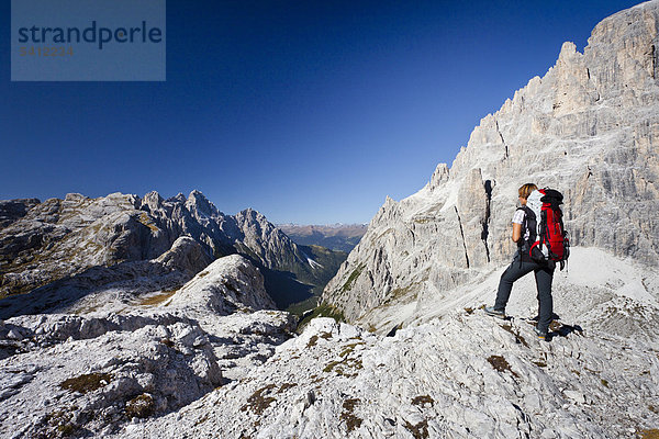 Bergsteiger im Alpinisteig  mit Blick auf den Einser  rechts der Elfer und Alpinisteig  hinten die Dreischusterspitze  Sexten  Hochpustertal  Dolomiten  Südtirol  Italien  Europa