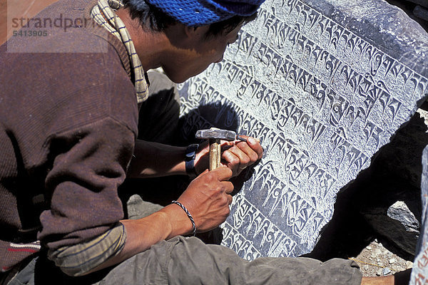 Mann meißelt tibetisch-buddhistische Mantras auf Steinplatte  Zanskar-Tal  Zanskar  Ladakh  Jammu und Kaschmir  indischer Himalaya  Nordindien  Indien  Asien