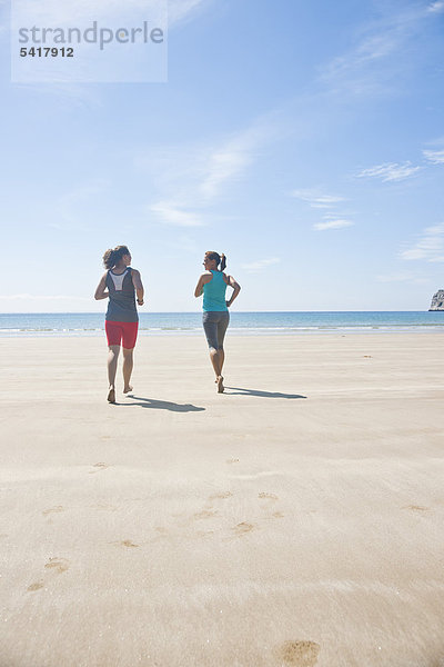 Zwei Frauen joggen am Strand