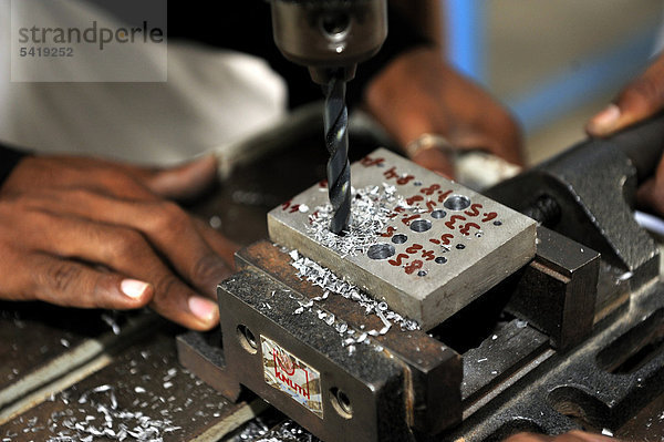Berufsausbildung zum Schlosser  Berufsschüler bohrt verschieden große Löcher in einen Stahlbarren  Youhanabad  Lahore  Punjab  Pakistan  Asien