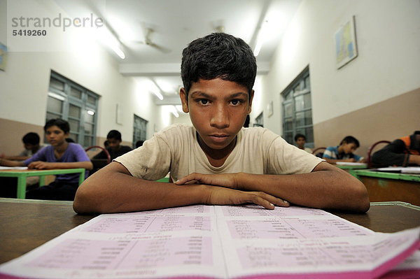 Schüler brütet über einem Lehrbuch  Unterricht in einer Middle School  Mittelschule  Youhanabad  Lahore  Punjab  Pakistan  Asien