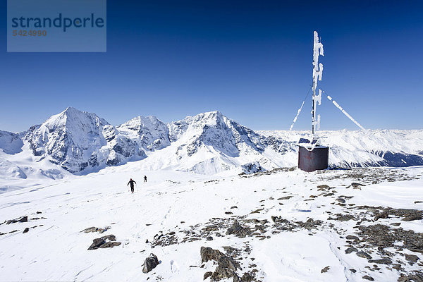 Skitourengeher auf dem Gipfel der hinteren Schöntaufspitze mit der Wetterstation  Sulden im Winter  hinten die Königsspitze  der Ortler und Zebru  Südtirol  Italien  Europa